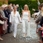 Couple walking through a confetti tunnel