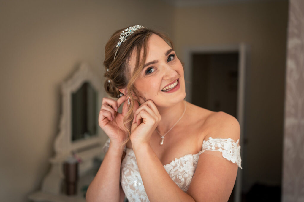 Bride putting in earrings for a personalised fun wedding