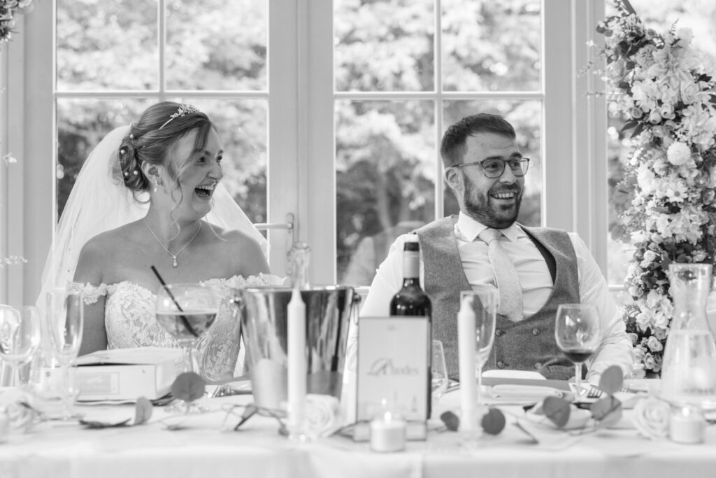Bride and groom laughing at the speeches for a personalised fun wedding