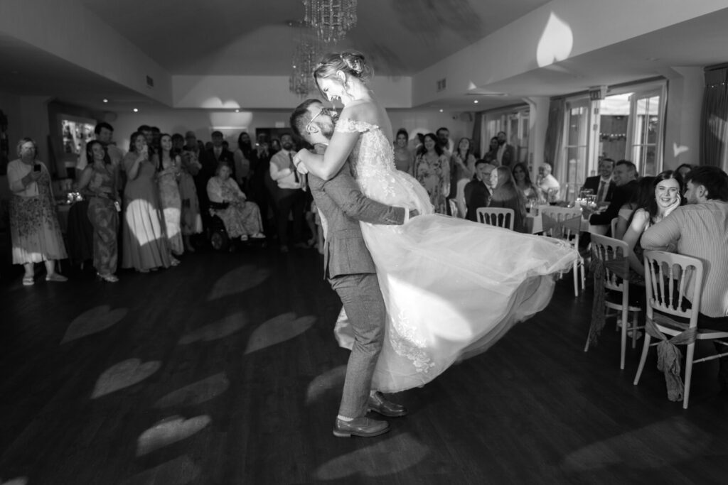 Groom lifting up bride during their first dance for a personalised fun wedding