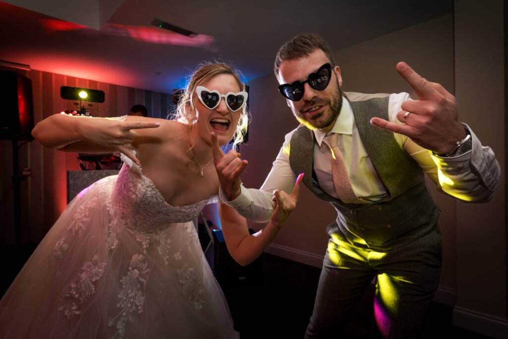 Bride and groom wearing heart sunglasses for a personalised fun wedding